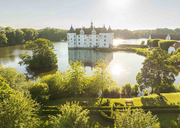 Wasserschloss Glücksburg mit Bäumen und Sonnenlicht