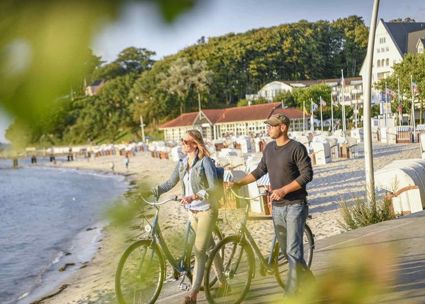 Mann und Frau mit Fahrrädern am Meer in Glücksburg
