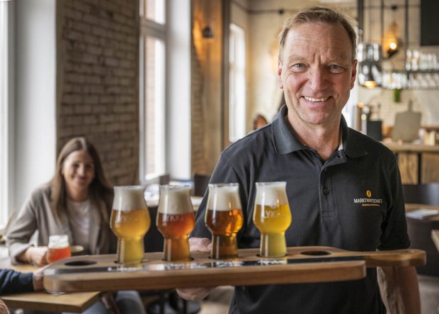 Mann mit Tablett und Biergläseren in der Gastronomie