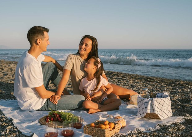 Familie macht Picknick am Strand