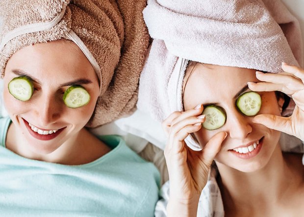Frauen mit Gurkenscheiben auf den Augen und Handtuchturban